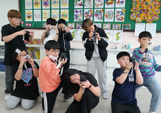 충북 괴산 청안초등학교 ‘예술꽃 씨앗학교’ 수업에 참여하면서 카메라를 소지하게 된 5학년 학생들이 사진촬영에 열중하고 있다.