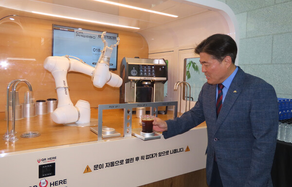 김영재 이사장은 지난 24일 한국식품산업클러스터진흥원에서 열린 제13회 국가식품클러스터 국제콘퍼런스 부대행사장에서 로봇이 내린 커피를 들어보이고 있다.